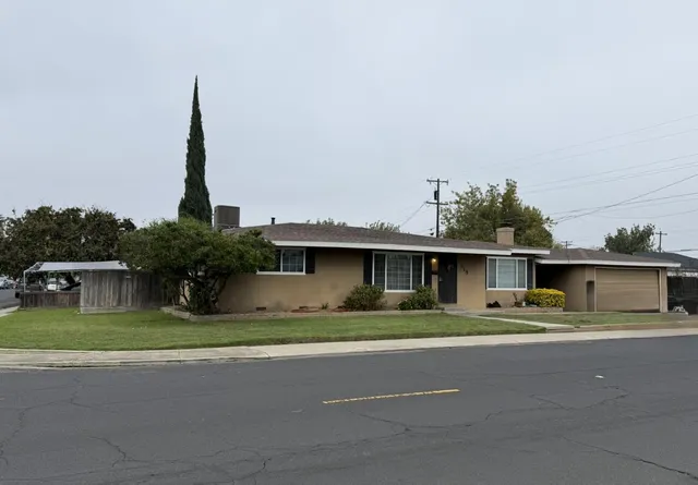 a front view of a house with a garden and plants
