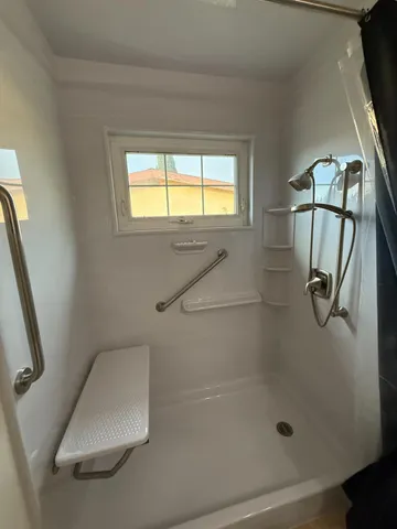 a bathroom with a granite countertop sink a mirror and shower