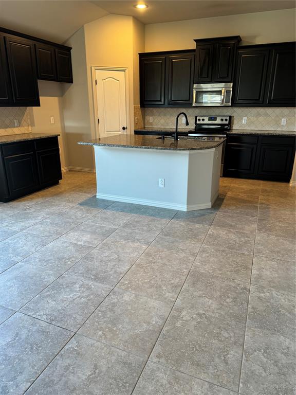 236 Archer Way Forney, TX 75126 - Photo 6 of 35 a kitchen with stainless steel appliances a sink a stove top oven a refrigerator and cabinets