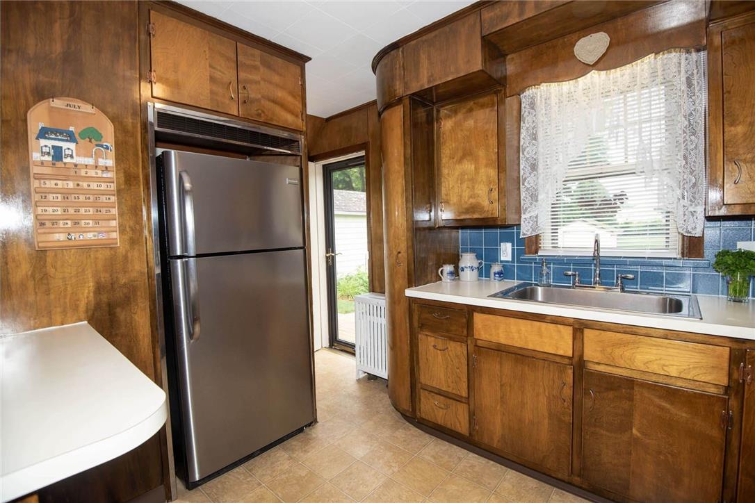 706 Stones Crossing Road Easton, PA 18045 - Photo 13 of 40 A well-equipped kitchen featuring abundant wooden cabinetry and a classic tile backsplash. The kitchen leads to the outdoors.