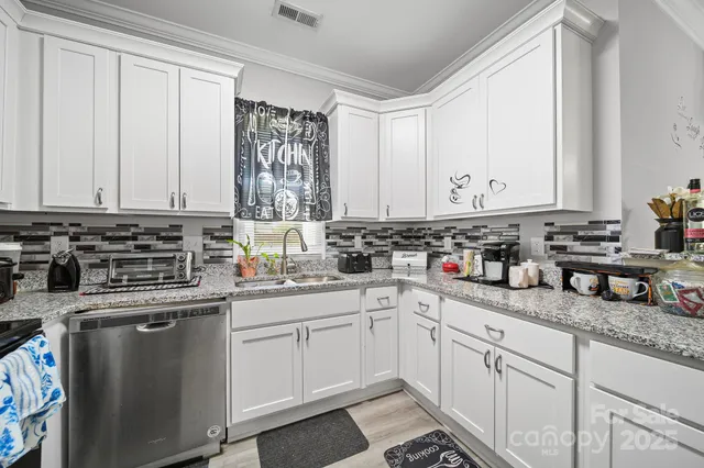 a kitchen with white cabinets and a sink