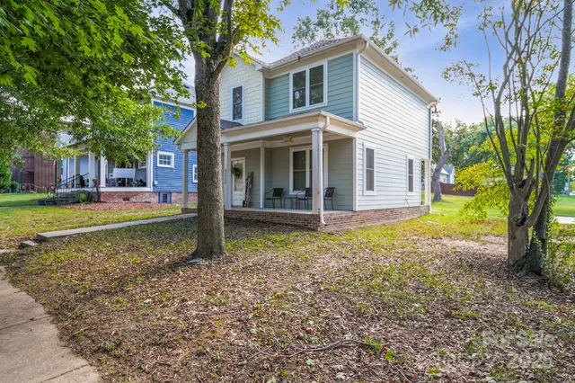 a view of a house with backyard and trees