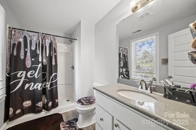 a bathroom with a granite countertop sink a vanity and a shower