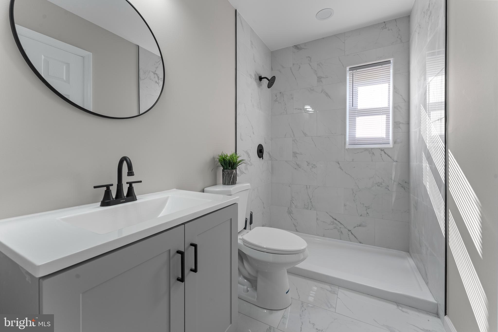215 Sykes Road New Castle, DE 19720 - Photo 11 of 12 a bathroom with a sink a toilet and a mirror