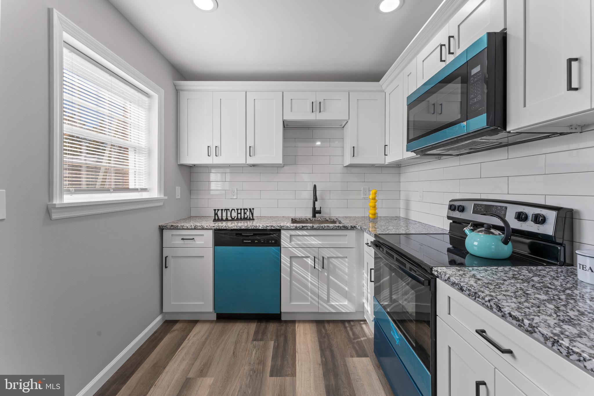 215 Sykes Road New Castle, DE 19720 - Photo 5 of 12 a kitchen with stainless steel appliances granite countertop a sink stove and microwave