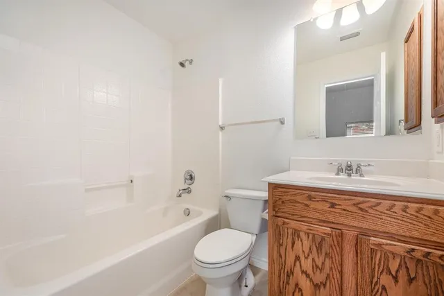 a bathroom with a granite countertop toilet a sink and a bathtub