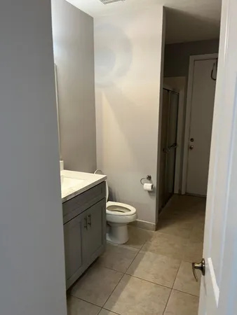 a bathroom with a granite countertop toilet and a sink