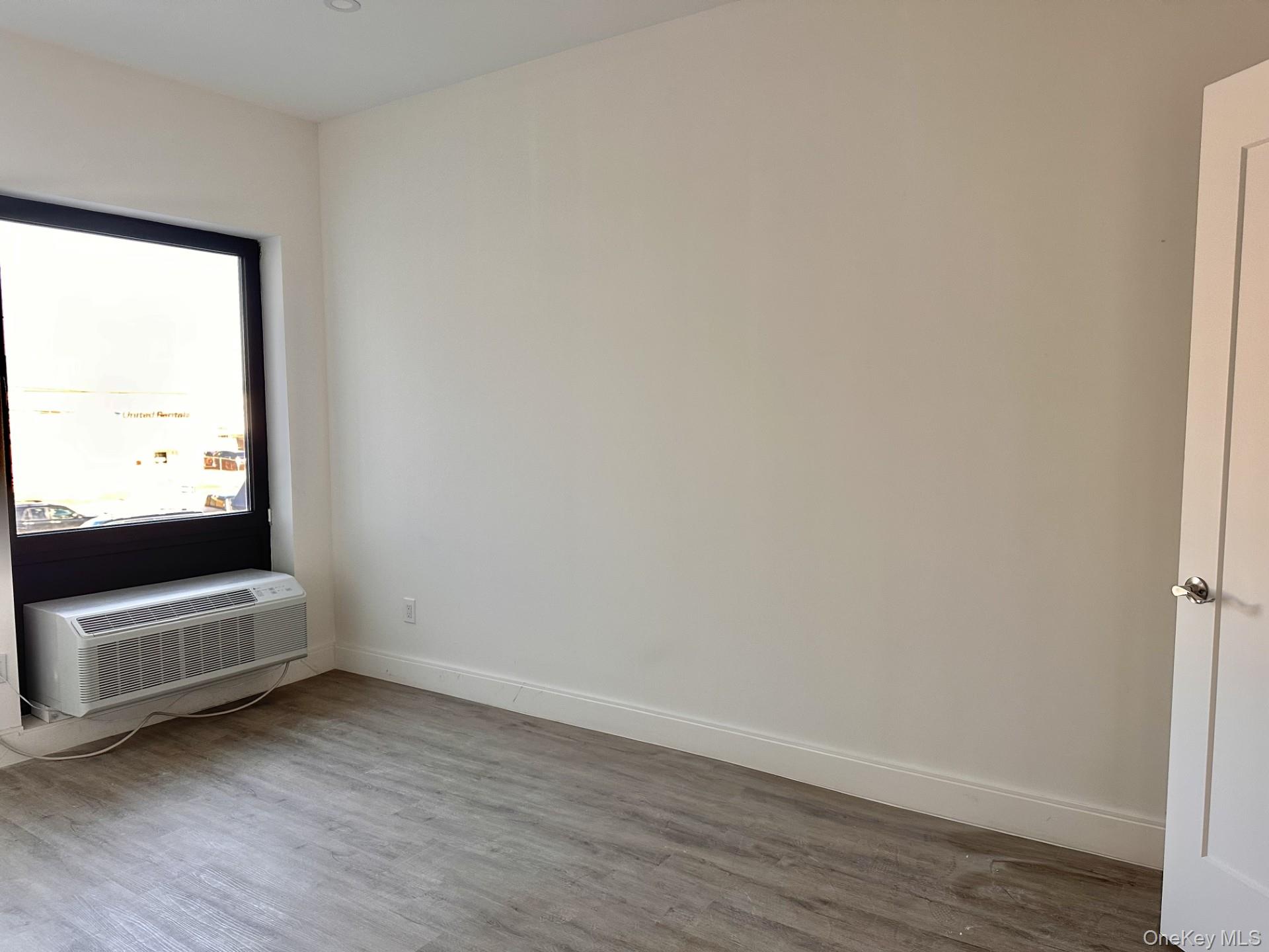 362 West Merrick Road, Unit 206 Valley Stream, NY 11580 - Photo 6 of 8 Spare room with baseboards and dark wood-style floors