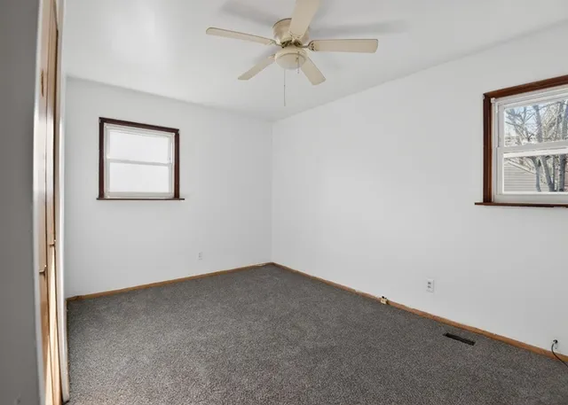 an empty room with chandelier fan