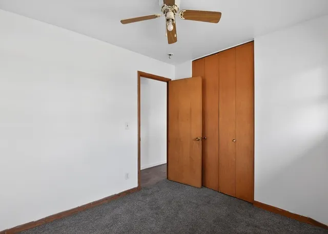 an empty room with closet and fan