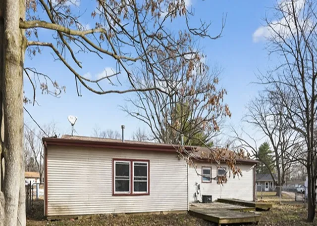 a front view of a house with a tree