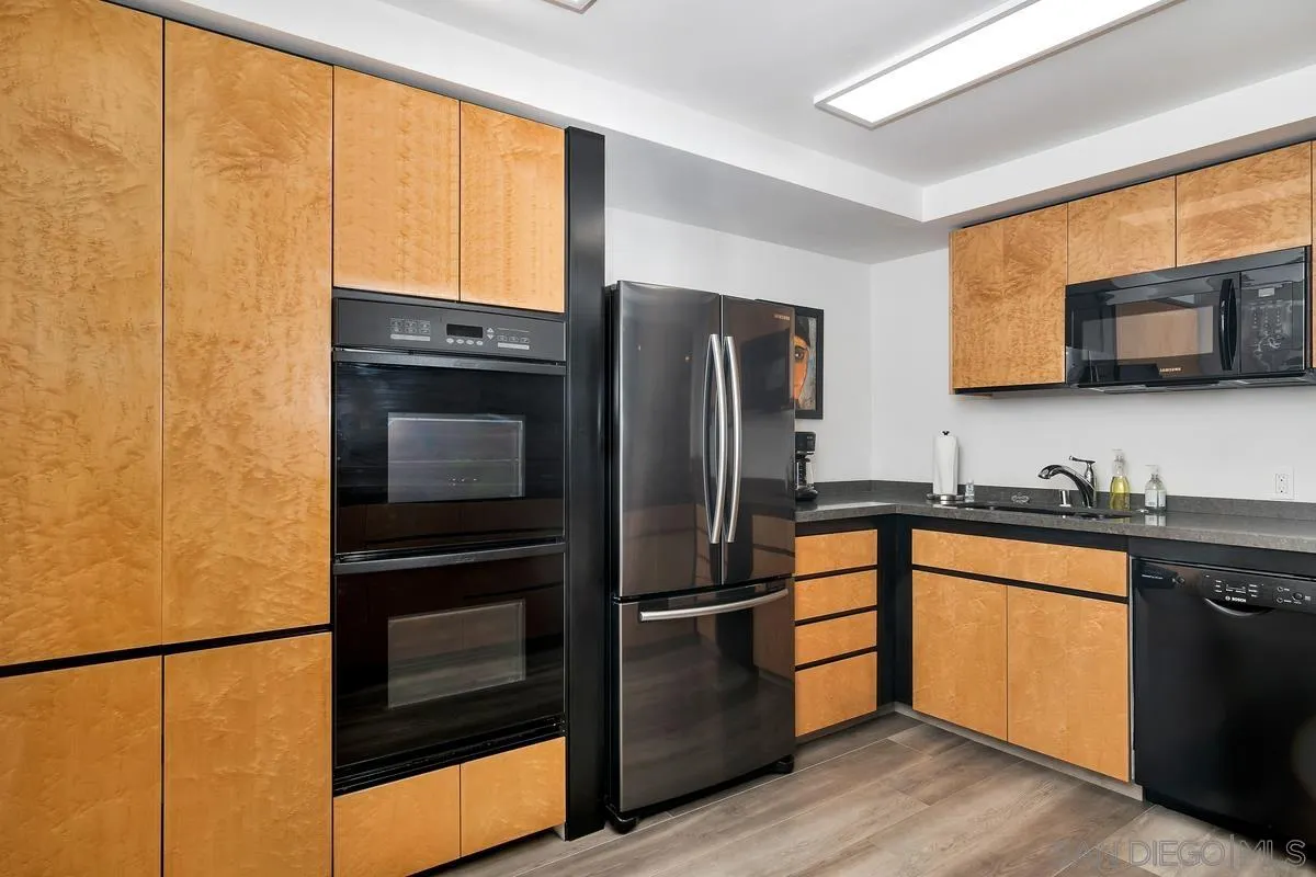 100 Coast Boulevard, Unit 304 La Jolla, CA 92037 - Photo 13 of 36 a kitchen with stainless steel appliances granite countertop a refrigerator and a sink