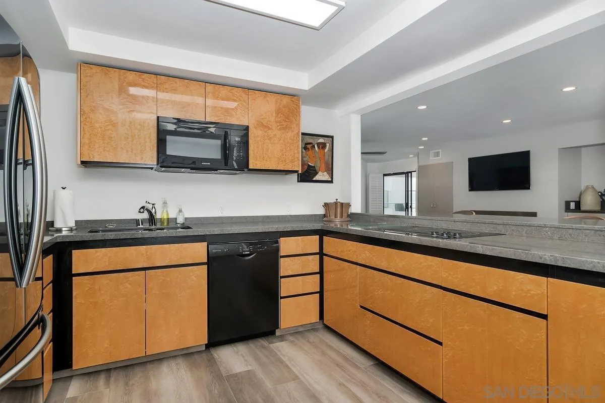 100 Coast Boulevard, Unit 304 La Jolla, CA 92037 - Photo 14 of 36 a kitchen with stainless steel appliances granite countertop a sink stove and microwave