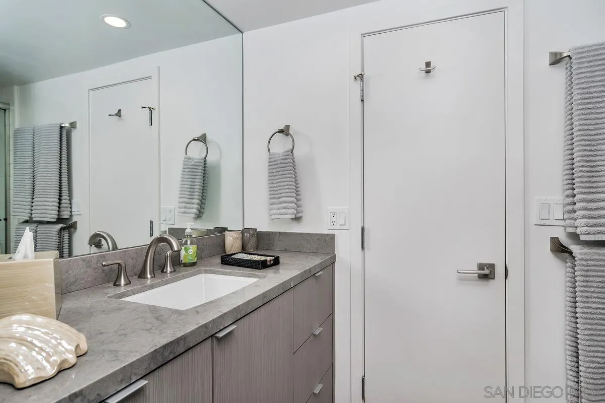 100 Coast Boulevard, Unit 304 La Jolla, CA 92037 - Photo 17 of 36 a bathroom with double vanity sinks and a mirror