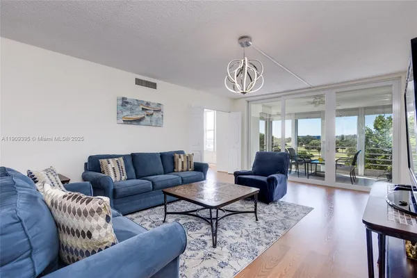a living room with furniture a lamp and a chandelier