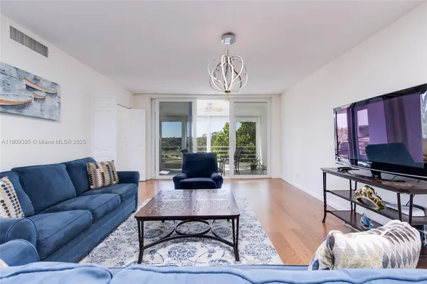 a living room with furniture a flat screen tv and a large window