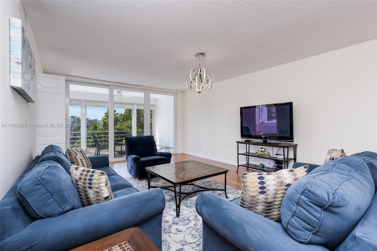 2671 South Course Drive, Unit 506 Pompano Beach, FL 33069 - Photo 13 of 31 a living room with furniture a flat screen tv and a large window