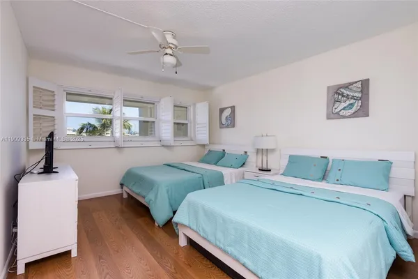 a bedroom with two beds and a chandelier