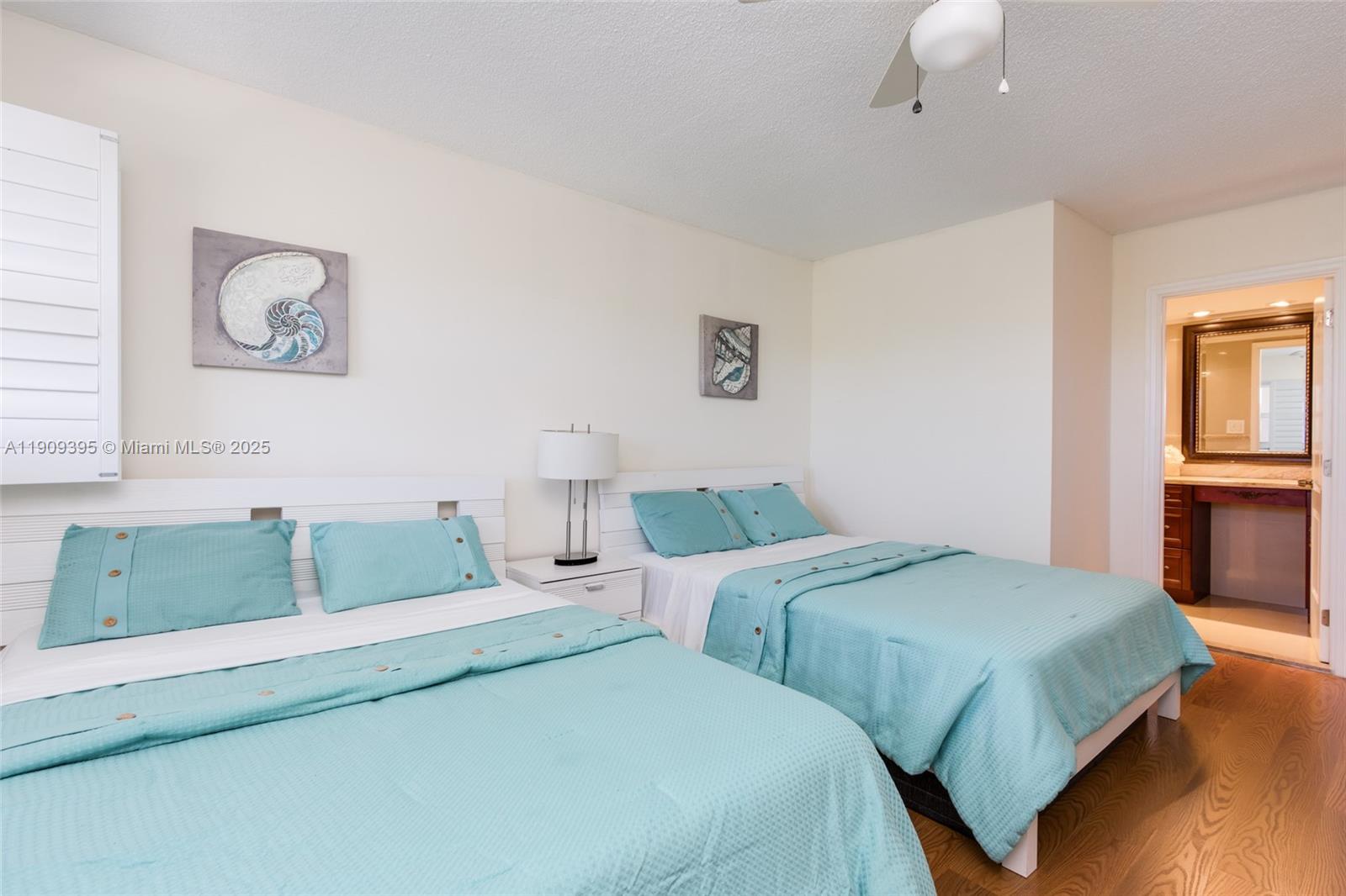 2671 South Course Drive, Unit 506 Pompano Beach, FL 33069 - Photo 16 of 31 a bedroom with two beds and a chandelier