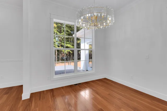a view of an empty room with wooden floor