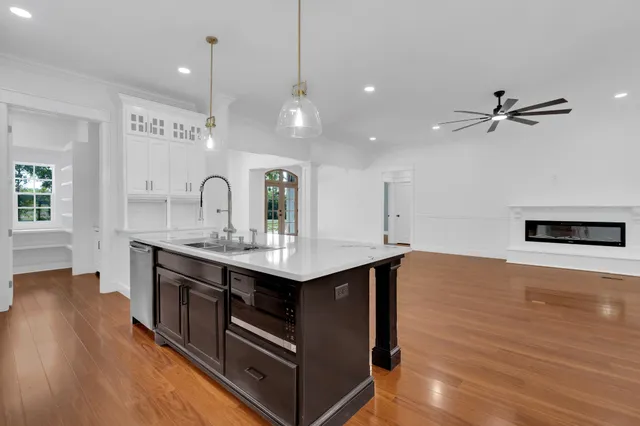 a kitchen with a sink cabinets and wooden floor