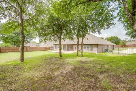 a view of a house with backyard and a tree