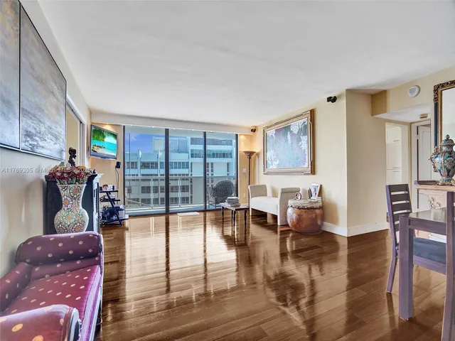 a living room with furniture large window and wooden floor