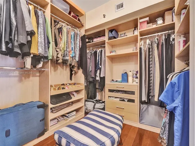 a view of walk in closet with clothes and shoes