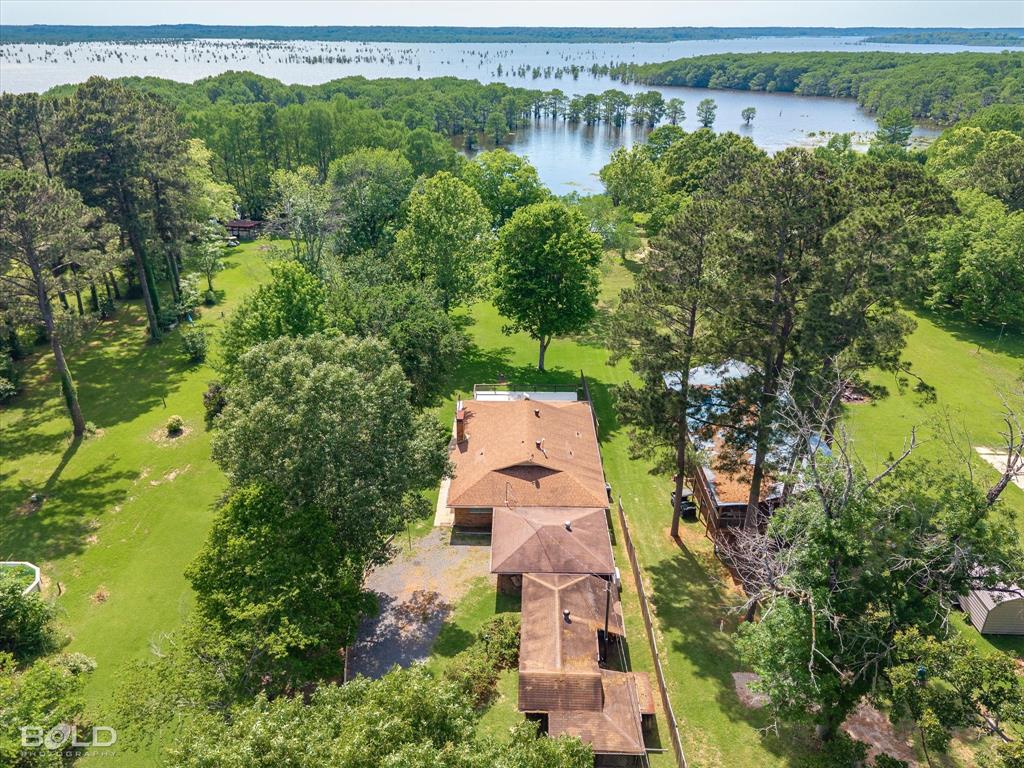 225 Marie Road Ringgold, LA 71068 - Photo 38 of 40 Expansive property featuring lush green lawns, mature trees, a visible roofline, and distant water frontage