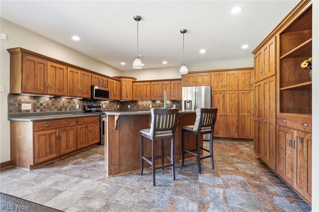 3199 Blake Road Wadsworth, OH 44281 - Photo 12 of 39 Gourmet kitchen featuring rich wood cabinetry with substantial storage, stainless steel appliances, and a large center island with seating