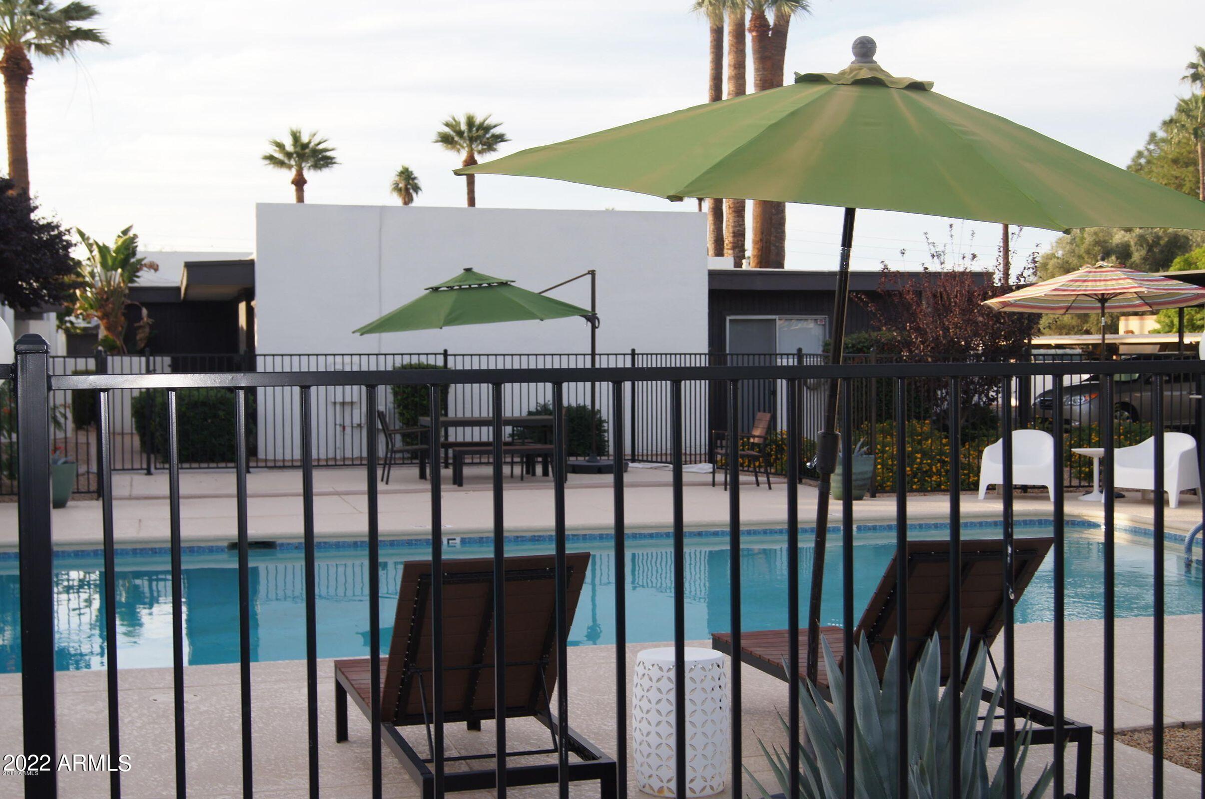 1250 East Bethany Home Road, Unit 17 Phoenix, AZ 85014 - Photo 25 of 25 a view of a patio with a table and chairs under an umbrella