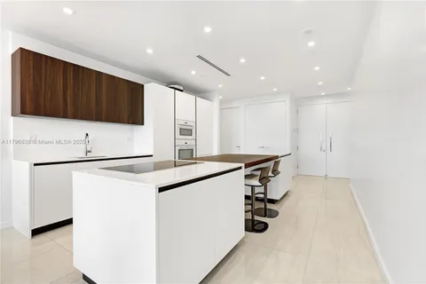 a kitchen with a refrigerator and a stove top oven