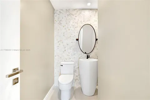 a bathroom with a toilet mirror and vanity