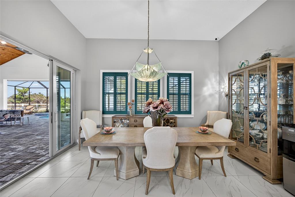 28991 Smugglers Lane Punta Gorda, FL 33982 - Photo 11 of 67 a dining room with furniture a chandelier and wooden floor