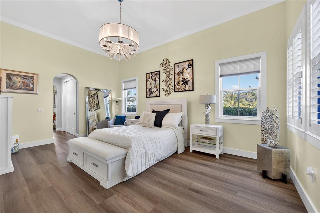 28991 Smugglers Lane Punta Gorda, FL 33982 - Photo 23 of 67 a spacious bedroom with a bed and a chandelier
