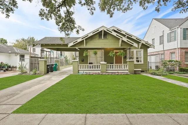 a front view of a house with a yard and trees