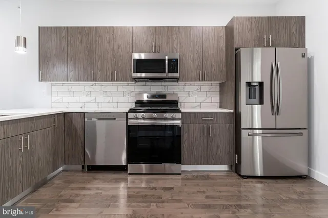 a kitchen with a sink stainless steel appliances and cabinets