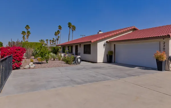 a view of a house with a yard and potted plants