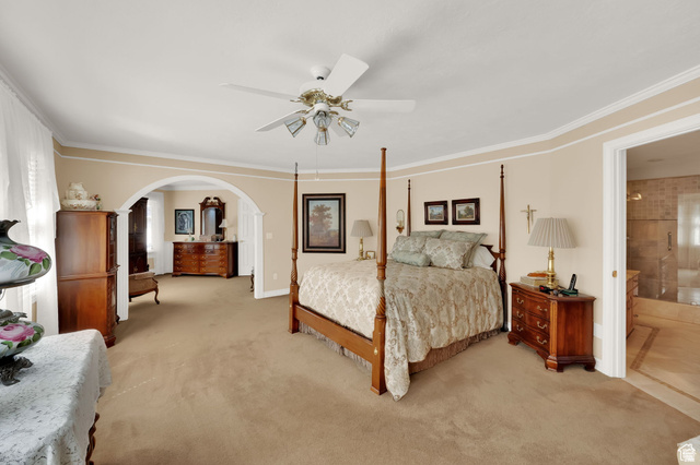 7740 Keswick Road Sandy, UT 84093 - Photo 31 of 74 Spacious bedroom featuring plush carpet flooring, a ceiling fan with integrated lighting, and a wide arched opening