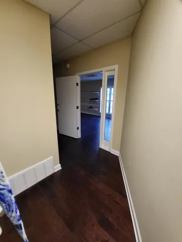 a view of a hallway with wooden floor