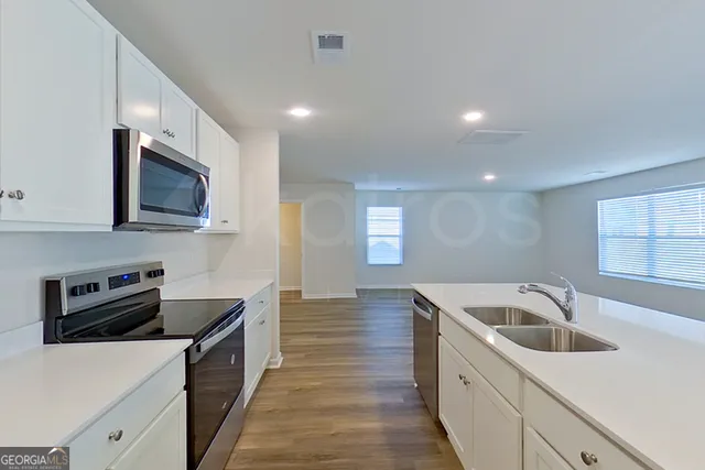 a kitchen that has a sink and a stove top oven