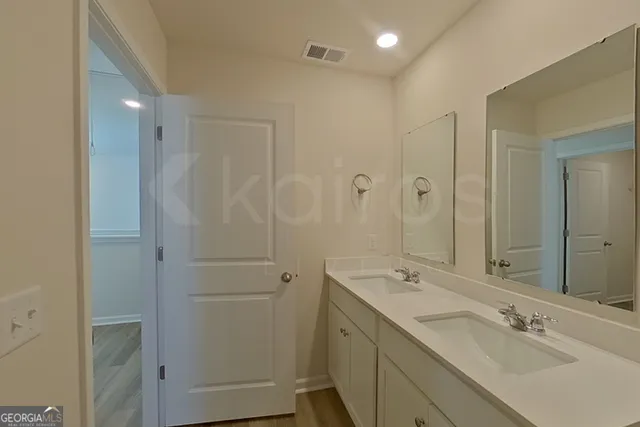 a bathroom with a double vanity sink a mirror and shower
