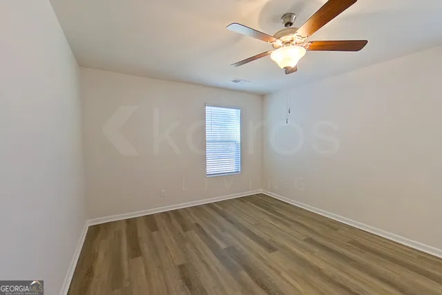 an empty room with a window and a fan