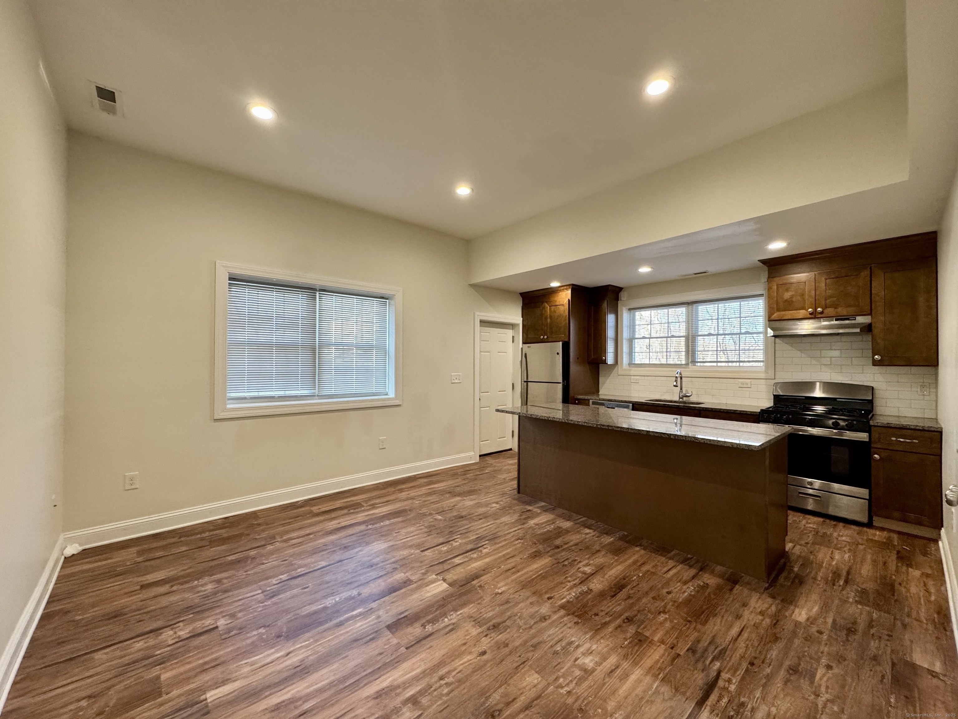 950 Lindley Street Bridgeport, CT 06606 - Photo 7 of 14 a large kitchen with stainless steel appliances granite countertop a large counter top space and wooden floor