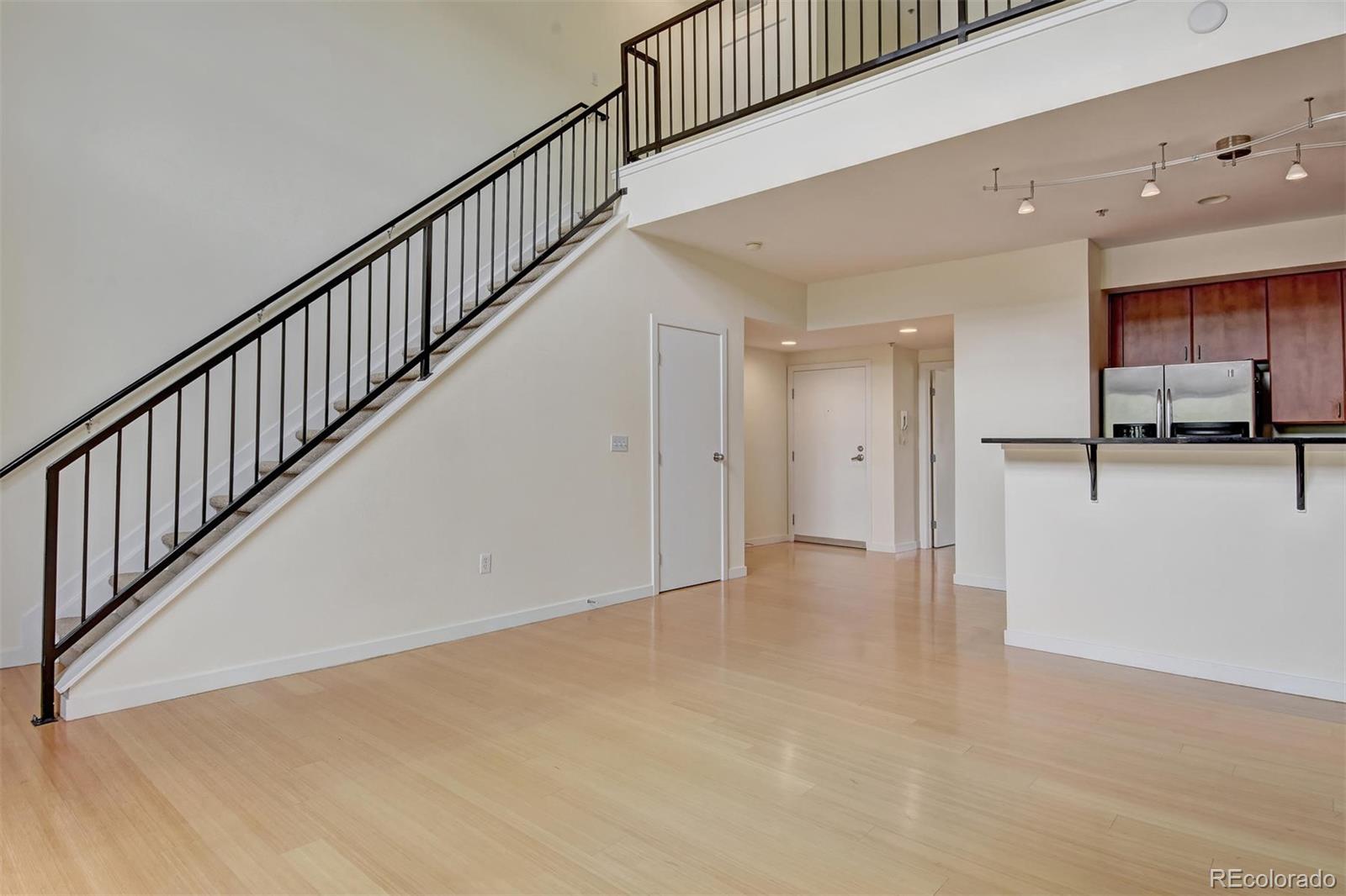 4520 Broadway, Unit 210 Boulder, CO 80304 - Photo 21 of 36 a view of a hallway with wooden floor and a kitchen