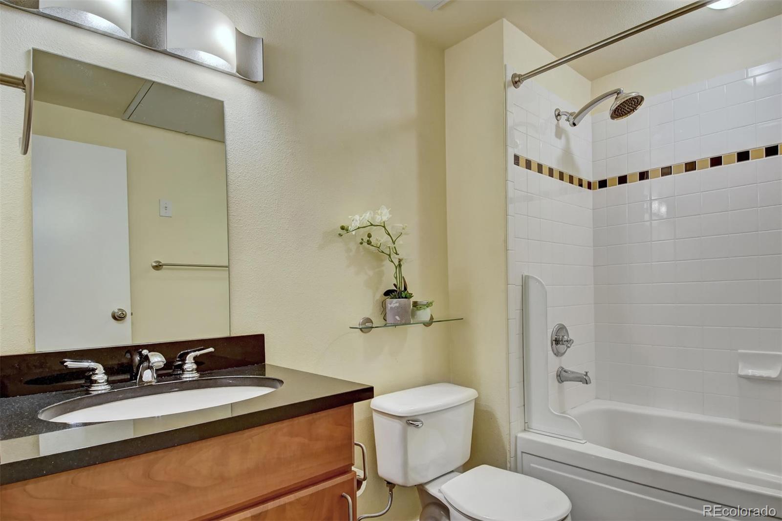 4520 Broadway, Unit 210 Boulder, CO 80304 - Photo 24 of 36 a bathroom with a granite countertop sink mirror toilet and bathtub