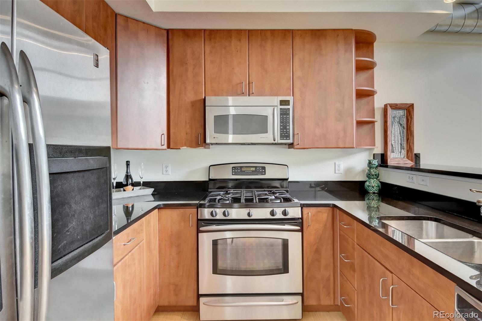 4520 Broadway, Unit 210 Boulder, CO 80304 - Photo 9 of 36 a kitchen with stainless steel appliances granite countertop a stove a sink and a microwave