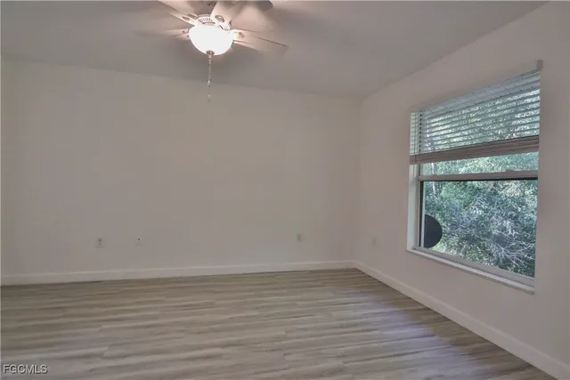a view of wooden floor and chandelier fan in a room