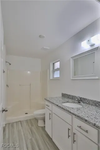 a bathroom with a granite countertop sink and mirror