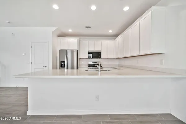 a kitchen with stainless steel appliances granite countertop a sink a stove and a refrigerator